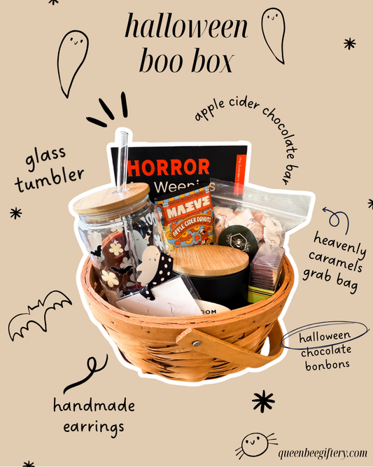 basekt with halloween chocolate bonbons, chocolate bar, handmade earrings, glass tumbler, book, and candle