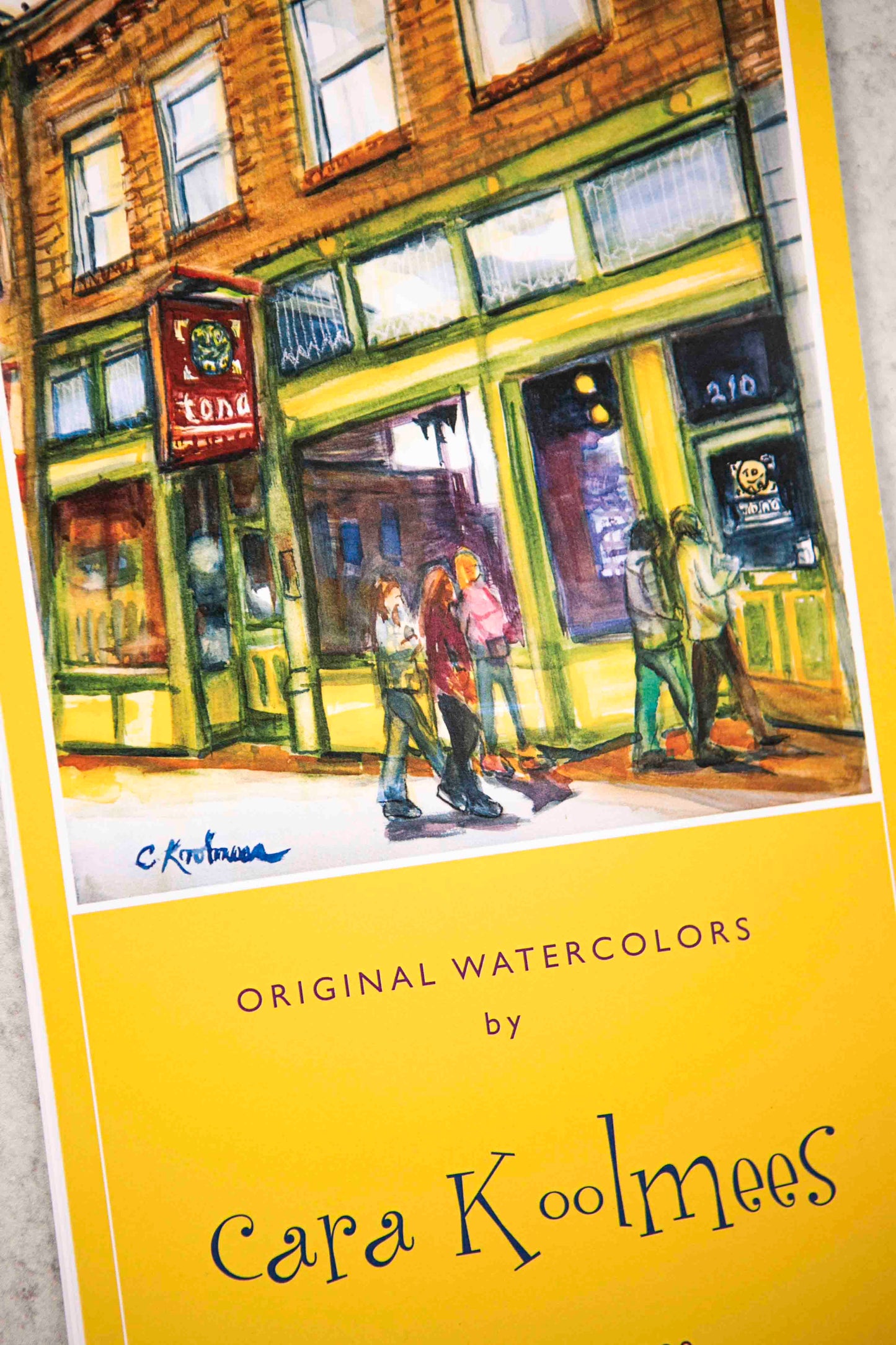 Book cover of 'Original Watercolors by Cara Koolmees' with a painting of a street scene.