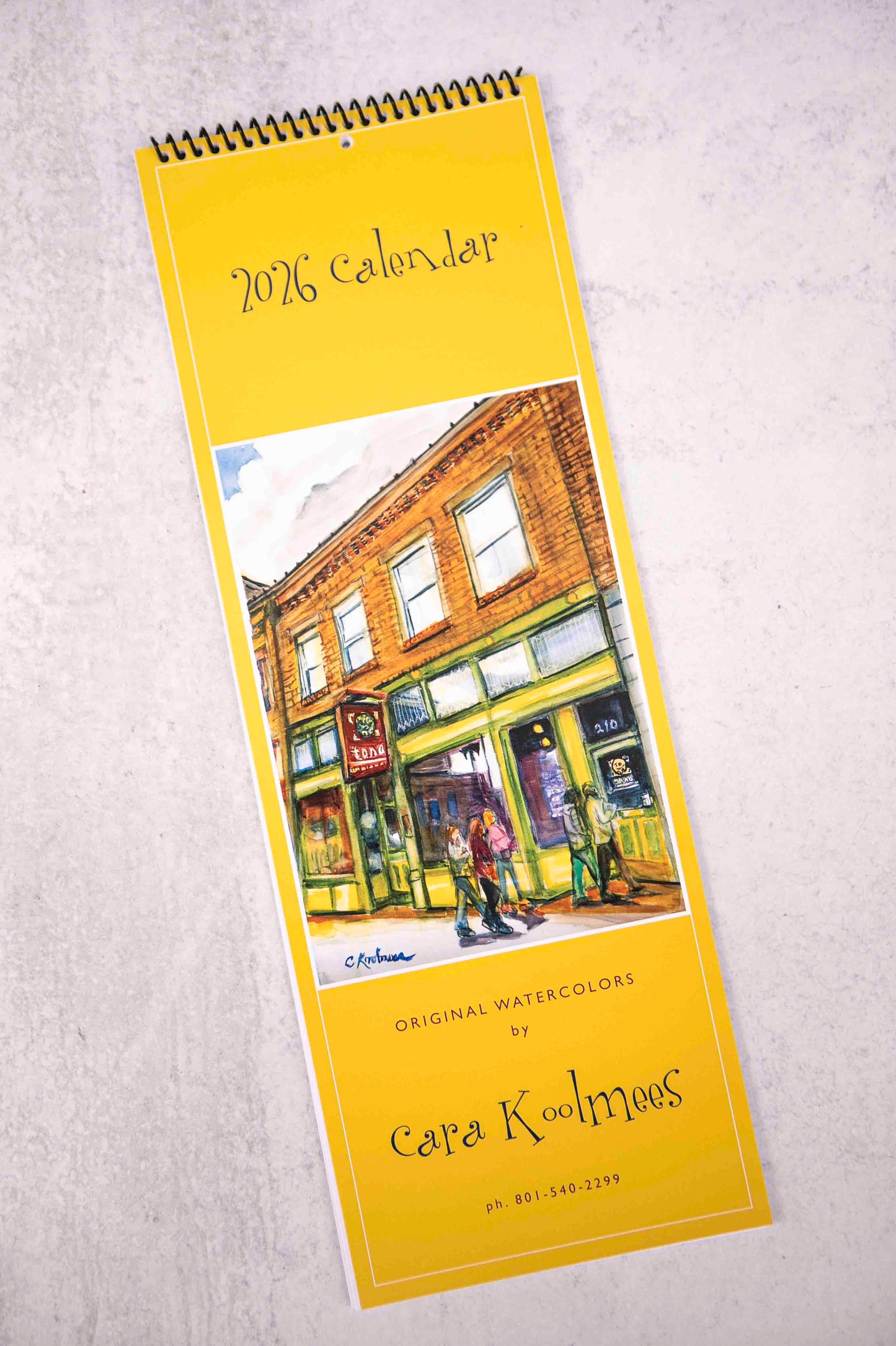 2026 calendar with a painting of a street scene on a yellow background