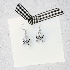 Spider earrings on a white card with a black and white checkered ribbon