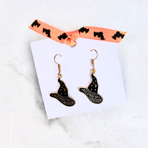 Halloween-themed with hats that say "wizard in training" on a white card with a ribbon, on a marble surface