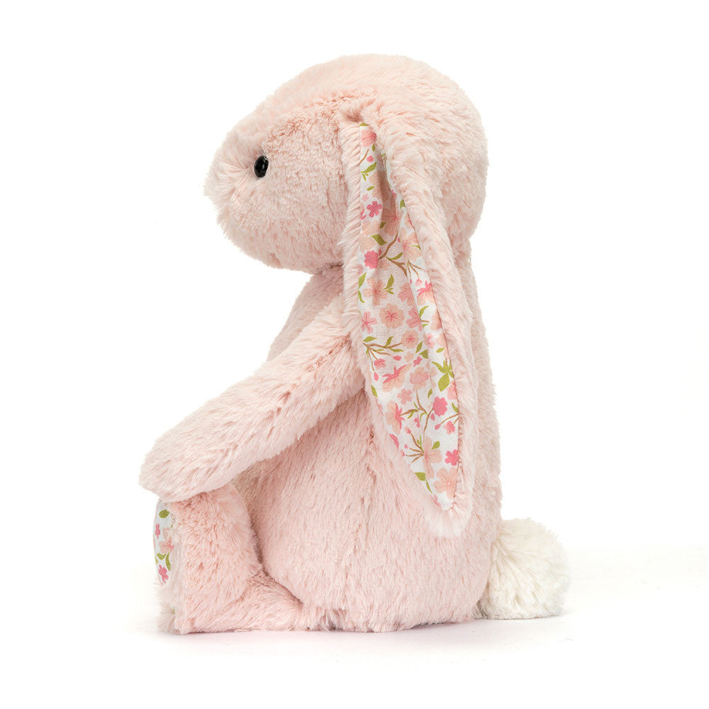 Pink plush bunny with floral patterned ear on a white background