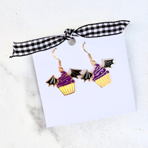 Dangly bat cupcake earrings on a white surface