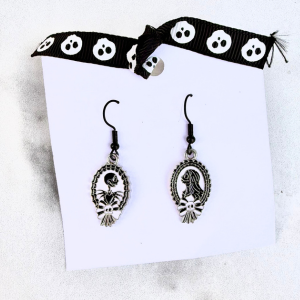 Pair of silver earrings with Jack and Sally on a white card with a black and white skull headband in the background.