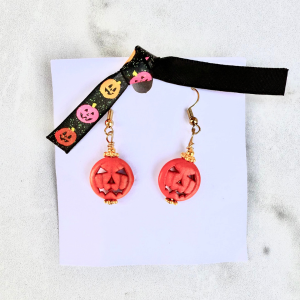 Pair of jack o lantern earrings on a white background