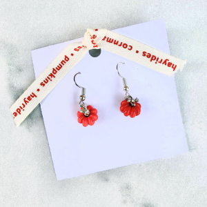Small pumpkin earrings on a card with text on a marble surface