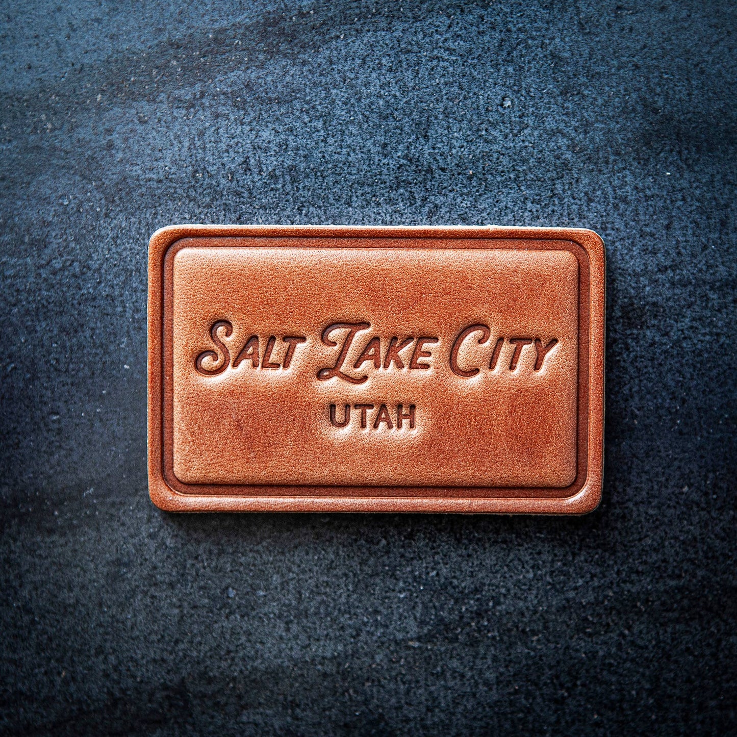 Brown leather rectangle magnet with 'Salt Lake City, Utah' text on a dark textured background