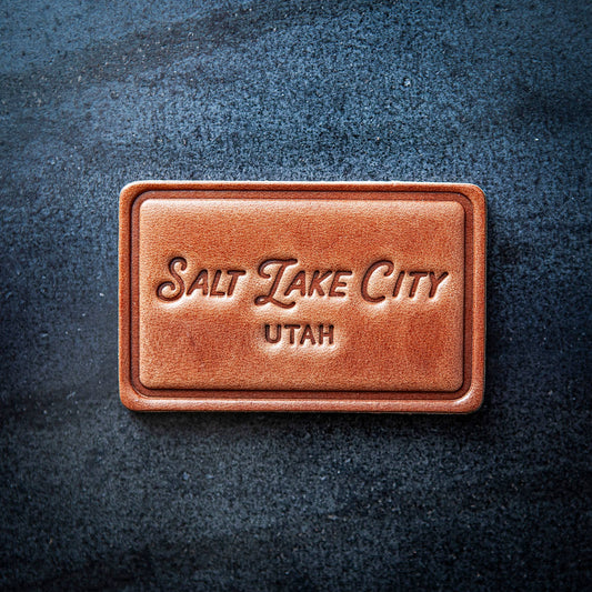 Brown leather rectangle magnet with 'Salt Lake City, Utah' text on a dark textured background
