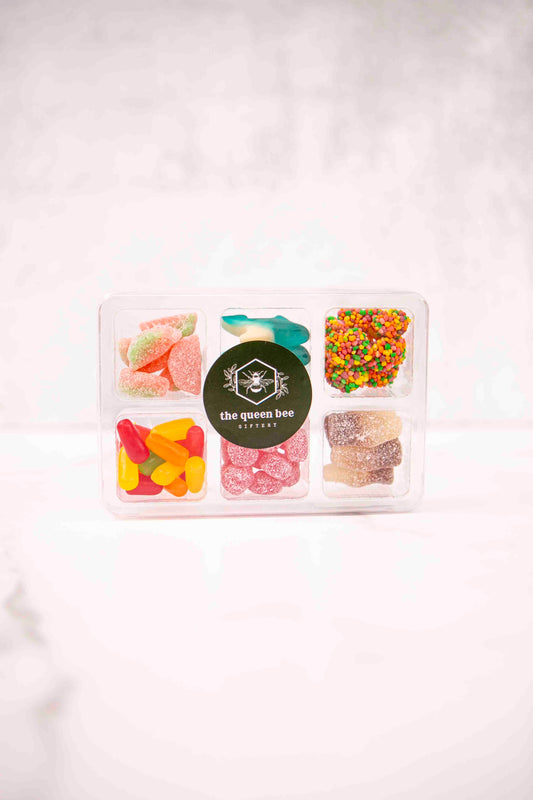 Assorted gummy candies in a clear container with a visible brand label on a white background