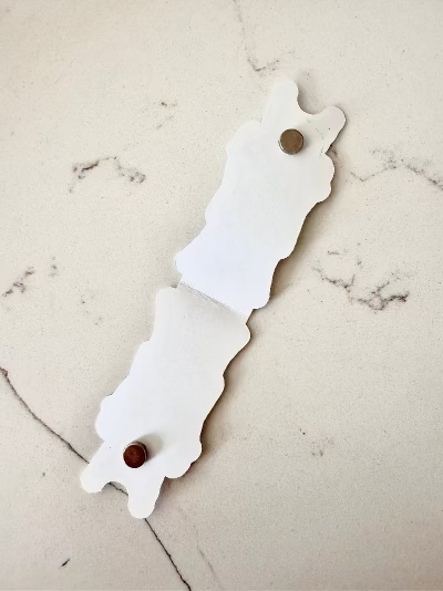 magnetic bookmark opened to reveal how magnets work on marble surface