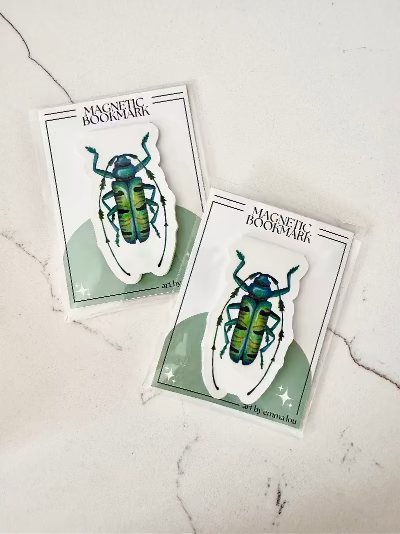 Two magnetic bookmarks with beetle design on a marble surface